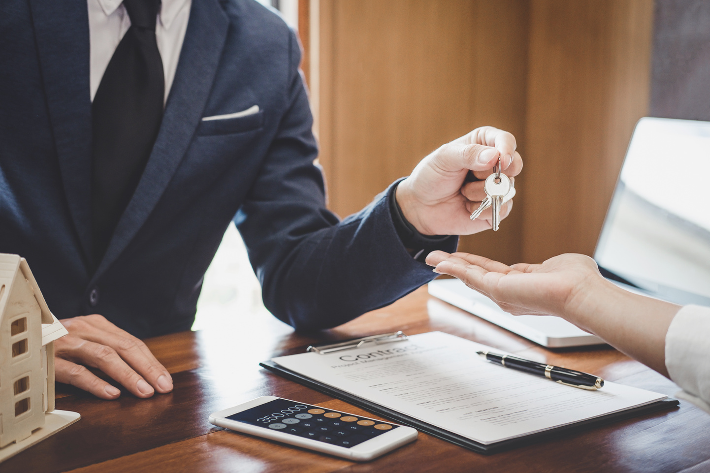 Real Estate Agent Sales Manager Holding Filing Keys to Customer